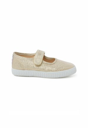 Chaussure Mary Jane dorée pailletée avec semelle en caoutchouc blanc, bride réglable et bout arrondi. Dessus en tissu doux avec doublure intérieure lisse.