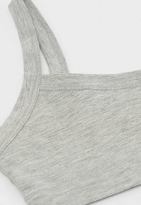 Šedý bavlněný tílko s tenkými ramínky, ribbovanou texturou a jednoduchým designem s čistým, nezdobeným okrajem.