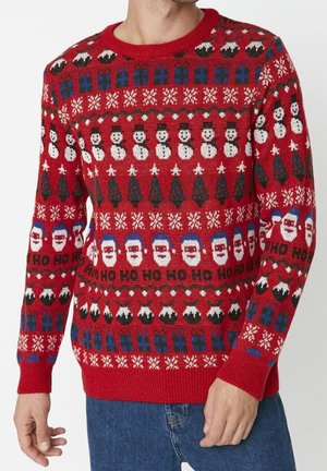Red knitted sweater featuring holiday patterns: snowmen, Christmas trees, Santa faces, and snowflakes. Ribbed cuffs and neckline.