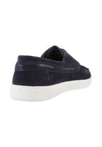 Marineblaues Wildleder-Slipper mit weißer Gummisohle, minimaler Naht und elastischen seitlichen Akzenten für einfaches Anziehen.