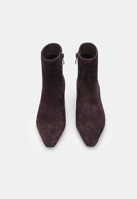Hnědé semišové kotníkové boty se špičatou špičkou a bočními zipy, které mají hladkou texturu a minimalistický design.