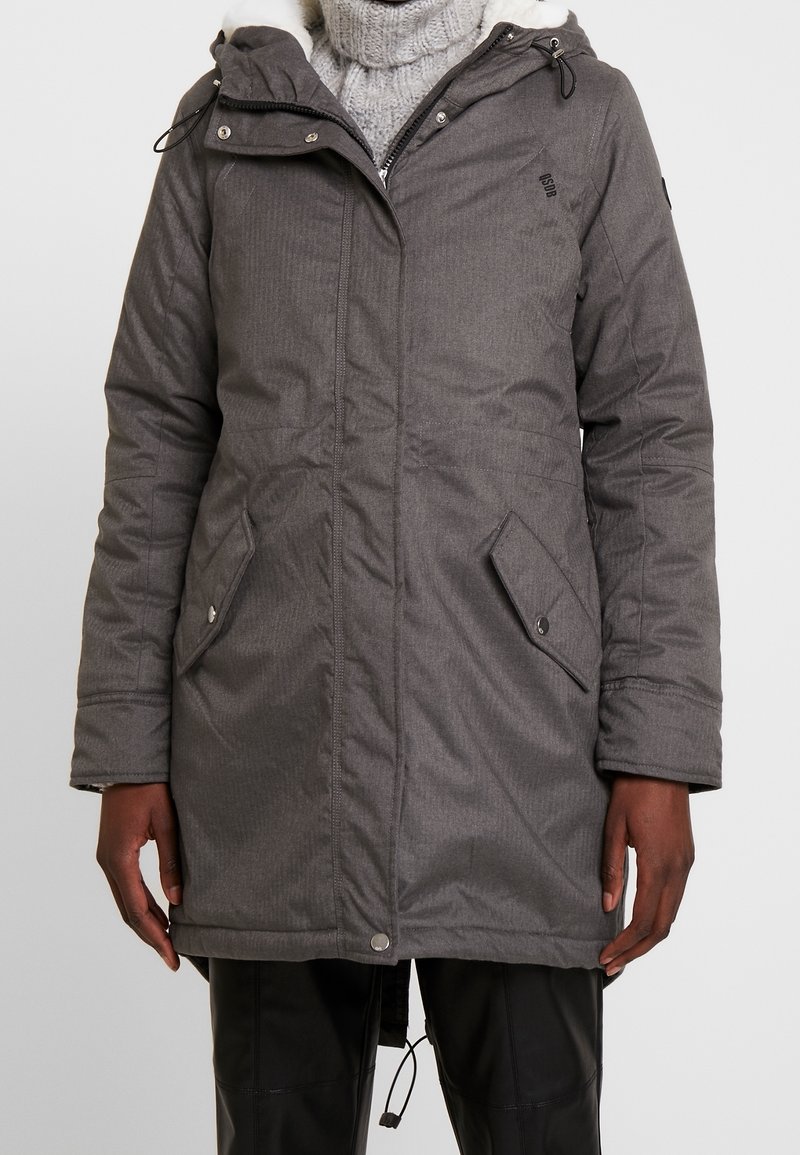 Giubbotto a compressione grigio con zip anteriore, cappuccio regolabile e due tasche laterali con chiusura a scatto. Presenta un tessuto testurizzato e una morbida fodera interna.