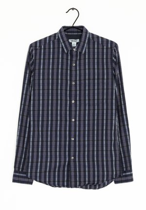 Camisa de cuadros azul marino y celeste de manga larga con cuello botón, botones de metal y un bolsillo en el pecho. Fabricada con una tela de textura suave.