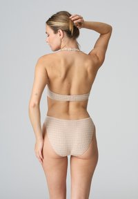 Beige bikini set featuring a textured halter neck top and high-waisted bottom with a subtle pattern. Adjustable strap with hardware detail.