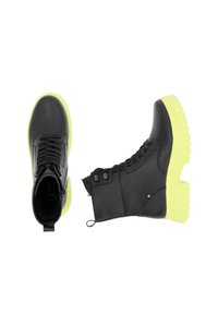 Schwarze Leder-Stiefeletten mit einer klobigen, leuchtend gelben Sohle, Schnürung vorne, Reißverschlussdetails und gepolstertem Kragen für Komfort.
