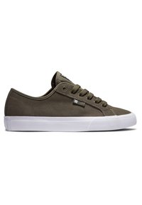 Zapatilla de lona verde oliva con suela de goma blanca, punta redondeada y cordones planos. Cuenta con una pequeña etiqueta de la marca en el lado.