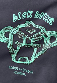 Gestileerde turquoise omtrek van een brullende berenkop met de tekst "Black Bananas" erboven en "Viva La Vida Transform The Generation" eronder op donkere stof.