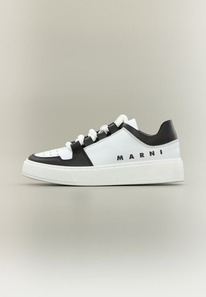 Άσπρο και μαύρο χαμηλό sneaker με άσπρα κορδόνια, παχιά σόλα και το "MARNI" τυπωμένο στο πλάι, εμφανίζεται σε απλό φόντο.