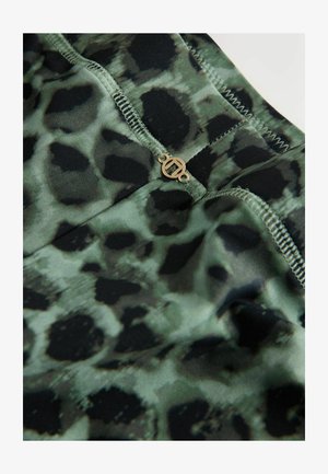 Zielono-czarna tkanina w zwierzęcy wzór o gładkiej fakturze, z małym złotym logo jako akcentem oraz kontrastującym przeszyciem wzdłuż szwów.