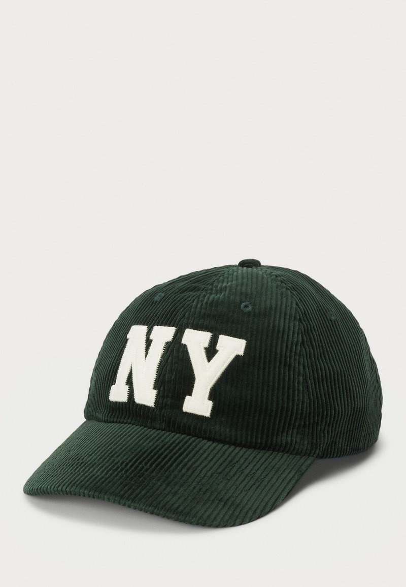 Boné de beisebol de veludo cotelê verde com uma aba curva e letras brancas "NY" na frente. Apresenta furos de ventilação costurados na parte de cima.