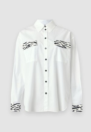 Camisa blanca de manga larga con estampado de cebra negra en los bolsillos del pecho y los puños, con cuello clásico y cierre de botones.