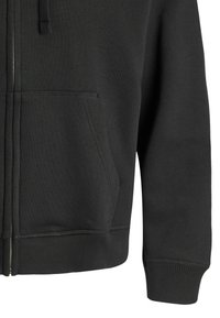 Schwarze Zip-Up-Hoodie aus Baumwollgemisch. Verfügt über eine Fronttasche sowie gerippte Bündchen und Saum. Glatte Textur mit minimalen Nähdetails.
