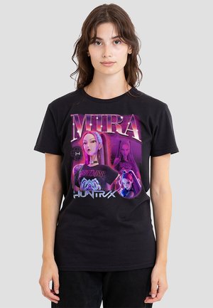 Young woman wearing black T-shirt with purple graphic of animated character "Mira" and text "HUNTR X" on front.