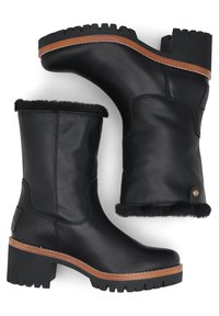 Botas de tobillo de cuero negro con forro de piel, tacón grueso, suela negra resistente y acento de madera alrededor del tacón. Detalles de diseño únicos y estilizados.