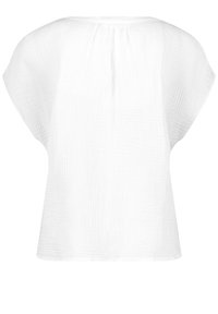 Blouse blanche texturée à manches courtes avec une coupe ample et des plis subtils au niveau du col, vue de dos.