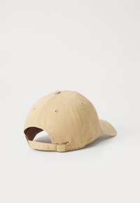 Gorra de béisbol color caqui con visera curva, correa ajustable en la parte posterior y ojales cosidos para ventilación. La tela tiene un acabado texturizado.