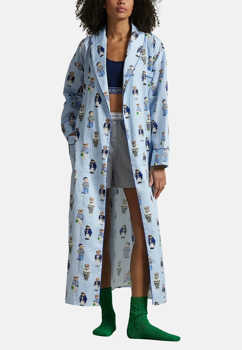 Blauwe en witte gestreepte lange robe met een speels dierenprint, gecombineerd met gestreepte korte broek en groene kniekousen. Katoenen stof.