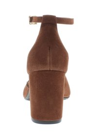 Brown suede high-heeled shoe with a chunky heel, an ankle strap, and a rounded toe. Textured surface with a sleek design.