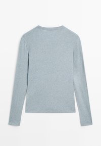 Camicia a maniche lunghe, di colore azzurro chiaro, realizzata in tessuto morbido, con scollatura rotonda e texture liscia, senza motivi visibili o decorazioni.