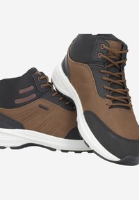 Chaussures montantes marron et noires en cuir et matériaux synthétiques, avec des textures contrastées, des semelles blanches et des lacets marron.