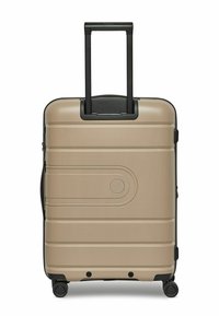 Maleta rígida en beige metálico, con una superficie texturizada, asa retráctil negra, ruedas de 360 grados y un detalle circular decorativo.
