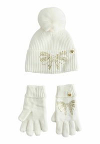 White ribbed knit beanie with a pom-pom and gold butterfly design; matching gloves with a similar pattern and a small gold heart accent.