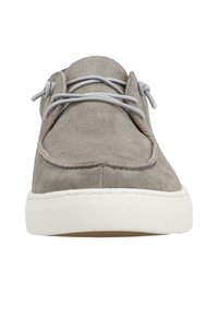 Grauer Wildlederschuh mit gepolstertem Zungenbereich, runder Spitze, grauen Schnürsenkeln und einer weißen Gummisohle. Minimale Nahtdetails entlang der Kante.