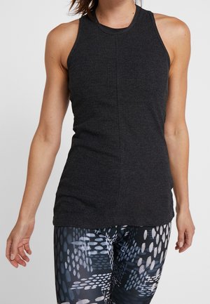 Zwarte geribde tanktop met een hoge halslijn en zonder mouwen, gecombineerd met patroonleggings in tinten blauw en wit.