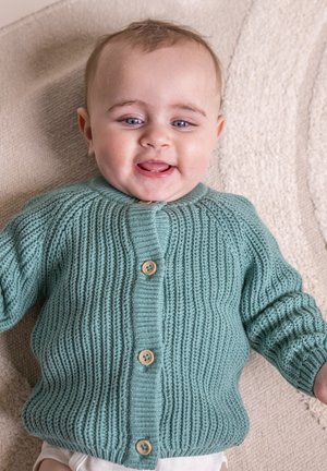 Cardigan en tricot bleu clair avec une texture côtelée, doté d'un col rond et de quatre boutons en bois à l'avant. Détail en tissu doux visible.