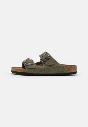 Green suede sandals with two adjustable straps, silver buckles, a cork footbed, and a textured black rubber sole.