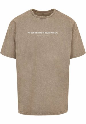 Tricou din bumbac de culoare bej prăfuit, cu o croială lejeră. Prezintă un guler tip crew și un text motivațional alb imprimat pe față.