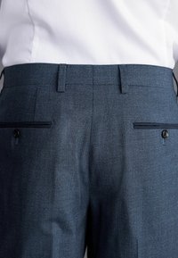 Dunkelblaue, maßgeschneiderte Hosen mit einem kleinen Karomuster, flachem Bund, zwei Gesäßtaschen mit Knöpfen und einer glatten Textur.