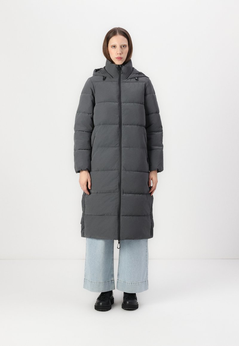 Grå dunjakke med hætte, prydet med en quiltet design, lange ærmer og en lige silhuet, sammen med brede lyseblå jeans.