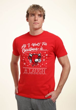 Rød bomulds t-shirt med et legende grafisk design af en køns ansigt med snefnug og teksten "Alt jeg ønsker mig til jul er... Et GRIN."