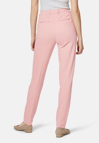 Pantaloni rosa su misura realizzati in morbido tessuto, con una vestibilità slim, tasche posteriori e una texture liscia, abbinati a ballerine beige.