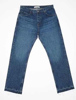 Jean en denim bleu avec une coupe droite, comportant cinq poches, un ourlet effiloché et un léger dégradé à l'avant. Étiquette du fabricant visible.