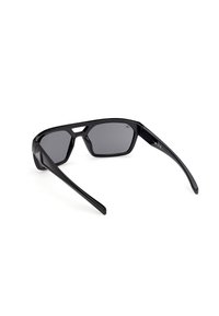 Lunettes de soleil noires angulaires avec verres foncés, monture épaisse et branches larges, vues sous un léger angle arrière sur fond blanc.