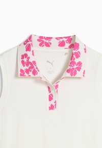 Λευκό πόλο πουκάμισο με ροζ γιακά με λουλουδάτο σχέδιο, κοντά μανίκια και πατιλέτα με τρία κουμπιά. Κατασκευασμένο από απαλό ύφασμα.