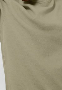 Světle olivově zelený dlouhý rukáv s texturovanou látkou, s kulatým výstřihem a mírným splýváním kolem ramen.