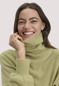 Hellgrüner, gerippter Rollkragenpullover mit weicher Textur. Verfügt über einen hohen Kragen und schmale Bündchen, lässig getragen mit einem lockeren Schnitt.