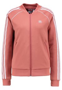 Pink athletic jacket with white striped accents on sleeves, ribbed cuffs and hem, and zip-front closure. Made of smooth, stretchy fabric.