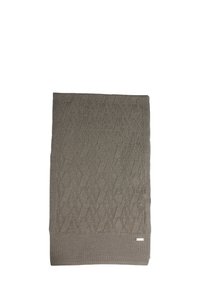 Coperta lavorata a maglia beige con motivo a diamante testurizzato, rifinita con un bordo solido e una piccola etichetta con logo nell'angolo. Bordi arricciati presenti.