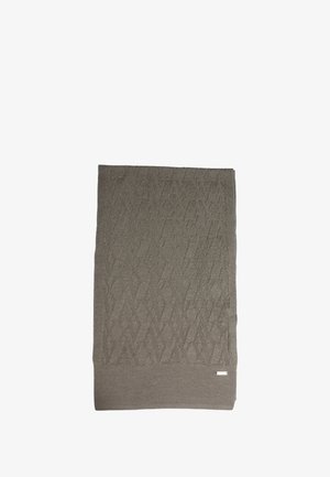 Coperta lavorata a maglia beige con motivo a diamante testurizzato, rifinita con un bordo solido e una piccola etichetta con logo nell'angolo. Bordi arricciati presenti.