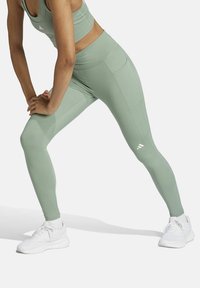 Lichte groene leggings met een aansluitend ontwerp, rekbare stof en een hoge taille. Heeft subtiele naden en een Adidas-logo op de dij.