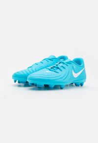 Kék focicipők textúrázott szintetikus felsőrésszel, fűzéses zárral és fehér Nike logóval. A talpon formázott stoplik találhatók a stabilitás érdekében.