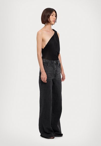 Sort one-shoulder bodysuit parret med højtaljede, løst siddende mørkegrå denimjeans med frontlommer og udsmykket talje.