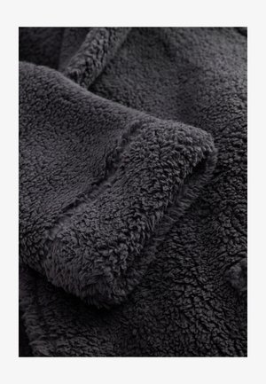 Dunkelgrauer Fleece-Stoff mit weicher, strukturierter Oberfläche und einem dicken, flauschigen Gefühl. Verfügt über eine glatte Kantenverarbeitung entlang der Manschette.