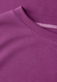 Lilla tekstil med en glat tekstur og en rund halsudskæring. Stoffet viser et subtilt, fint væv med en ren færdigbehandling.