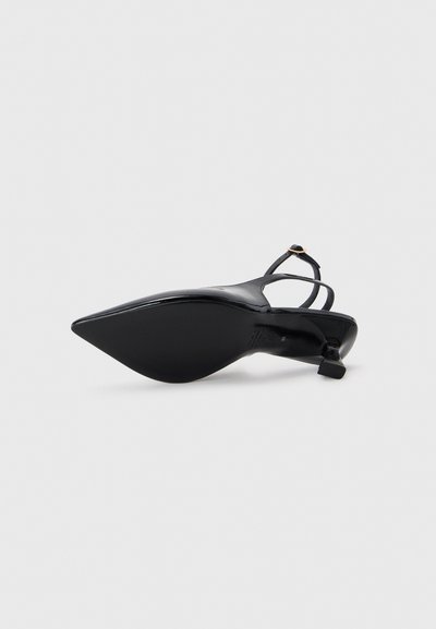 Mustat slingback-korkokengät, joissa on suippo kärki ja kiiltävä pinta. Ominaisuuksiin kuuluvat ohuet hihnat ja pieni neliön muotoinen korko. Koko kengän pinta on sileä.