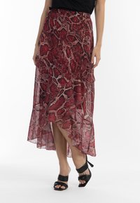 Sukně midi s hadím potiskem v červené barvě, lehký materiál, vrstvový design, asymetrický lem, v kombinaci s černými sandály na vysokém podpatku se šněrováním.